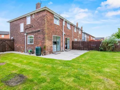 a brick house with a lawn in front of it at Spacious 3 Bedroom Home in Aintree in Liverpool