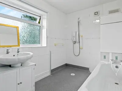 a white bathroom with a sink and a bath tub at Spacious 3 Bedroom Home in Aintree in Liverpool