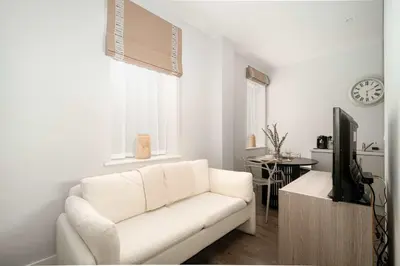 a white living room with a white couch and a tv at Modern Studio Apartment in Waterloo Liverpool in Liverpool
