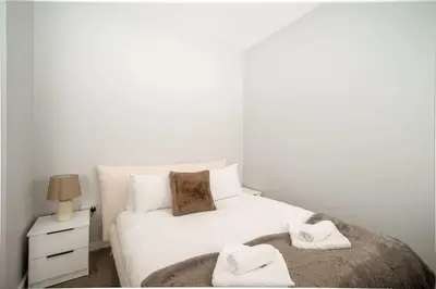 a bedroom with a white bed with towels on it at Modern Studio Apartment in Waterloo Liverpool in Liverpool