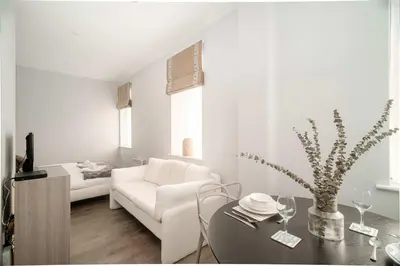 a white living room with a white couch and a table at Modern Studio Apartment in Waterloo Liverpool in Liverpool