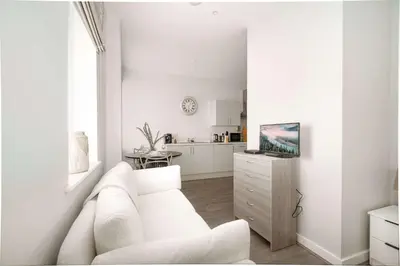 a white living room with a white couch and a kitchen at Modern Studio Apartment in Waterloo Liverpool in Liverpool