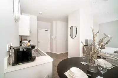 a white kitchen with a table and a microwave at Modern Studio Apartment in Waterloo Liverpool in Liverpool