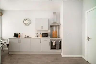 a kitchen with white cabinets and a stove at Modern Studio Apartment in Waterloo Liverpool in Liverpool