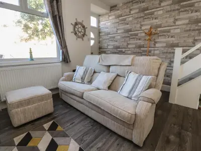 a living room with a couch and a stone wall at Harbour Mews in Lytham St Annes