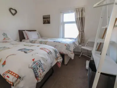 a bedroom with two beds and a ladder at Harbour Mews in Lytham St Annes