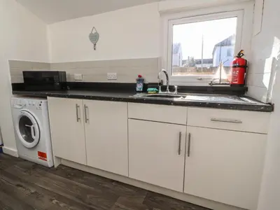 a kitchen with a sink and a washing machine at Harbour Mews in Lytham St Annes