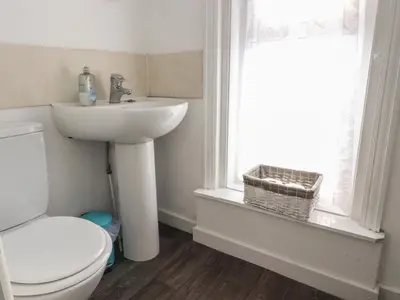 a bathroom with a toilet and a sink and a window at Harbour Mews in Lytham St Annes