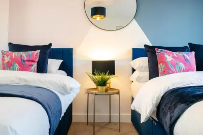 a bedroom with two beds and a mirror on the wall at Oriel Suite - Central - Contractors - 6 Beds in Liverpool