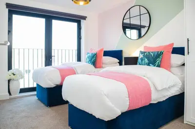 two beds in a room with a window at Oriel Suite - Central - Contractors - 6 Beds in Liverpool