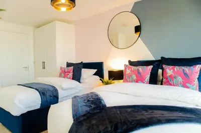 two beds in a room with a mirror on the wall at Oriel Suite - Central - Contractors - 6 Beds in Liverpool