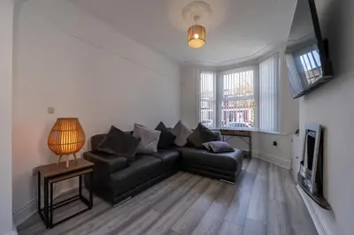 a living room with a black couch and a television at The place I remember in Liverpool