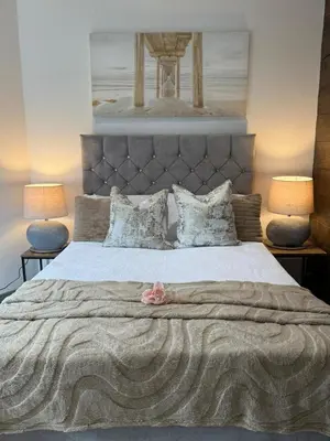 a bedroom with a large bed with a pink flower on it at J's Place in Blackpool