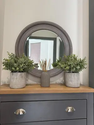 a mirror on top of a dresser with two plants at J's Place in Blackpool