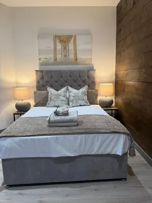 a bedroom with a large bed with two lamps at J's Place in Blackpool