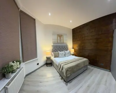 a bedroom with a large bed and a wooden wall at J's Place in Blackpool