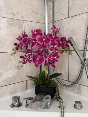 a vase of purple flowers sitting on a sink at J's Place in Blackpool