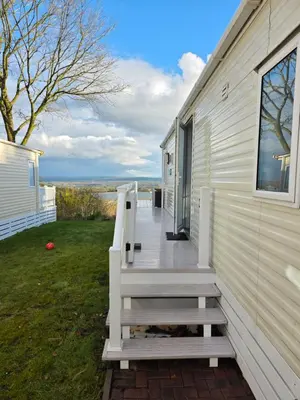 a porch of a white house with a wooden stairs at Tw Luxury Caravan in Longridge
