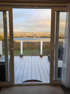 a sliding glass door with a view of a deck at Tw Luxury Caravan in Longridge