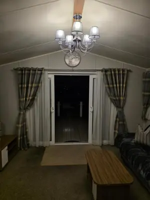 a living room with a couch and a chandelier at Tw Luxury Caravan in Longridge