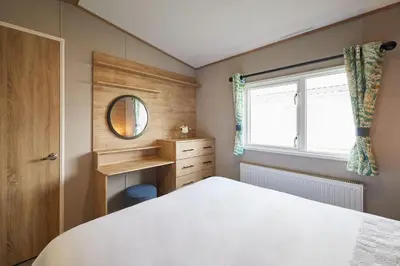 a bedroom with a bed and a mirror and a window at Host & Stay - Grange in Morecambe