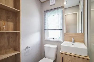 a bathroom with a toilet and a sink and a window at Host & Stay - Grange in Morecambe