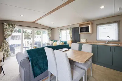 a caravan kitchen and living room with a table and chairs at Host & Stay - Grange in Morecambe