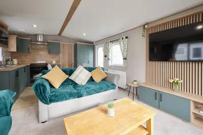 a living room with a couch and a kitchen at Host & Stay - Grange in Morecambe