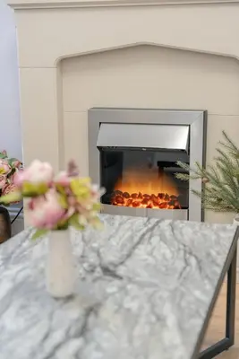 a vase of flowers on a table in front of a fireplace at Richmond Terrace - Cosy and Modern Stay in Darwen