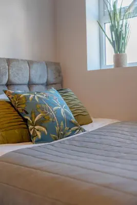 a bed with two pillows on top of it at Richmond Terrace - Cosy and Modern Stay in Darwen