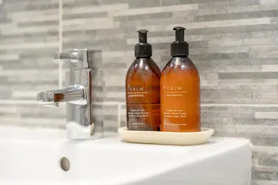 two bottles of soap sitting on top of a sink at Richmond Terrace - Cosy and Modern Stay in Darwen