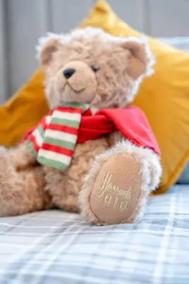 a teddy bear wearing a santa suit sitting on a bed at Richmond Terrace - Cosy and Modern Stay in Darwen
