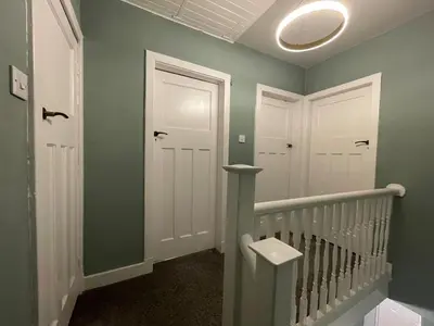a hallway with two white doors and a staircase at Surrey Street Retreat in Wallasey