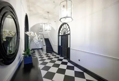a hallway with a black door and a checkered floor at Full Apartment with secure parking great views in Preston
