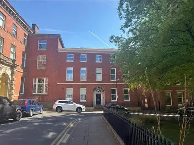a brick building with cars parked in front of it at Full Apartment with secure parking great views in Preston