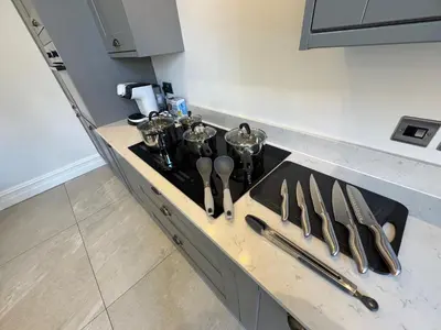 a kitchen counter with a stove top with silver utensils at Full Apartment with secure parking great views in Preston