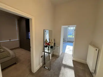 a room with a mirror and a bed and a door at Full Apartment with secure parking great views in Preston