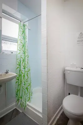 a bathroom with a shower with a toilet and a sink at The Beachfront Hotel in Blackpool