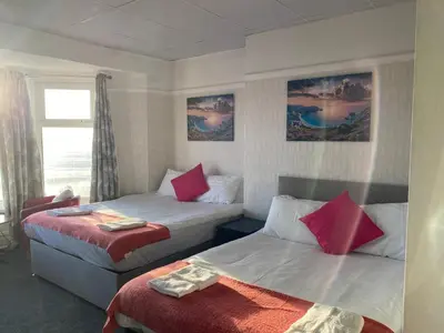 a hotel room with two beds and a window at The Beachfront Hotel in Blackpool