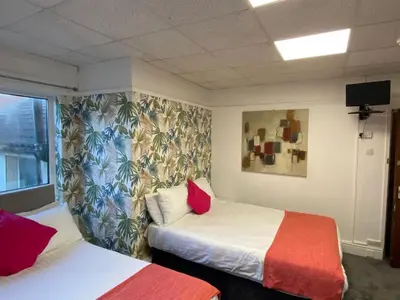 a hotel room with two beds and a window at The Beachfront Hotel in Blackpool