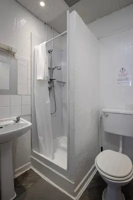a bathroom with a shower and a toilet and a sink at The Beachfront Hotel in Blackpool