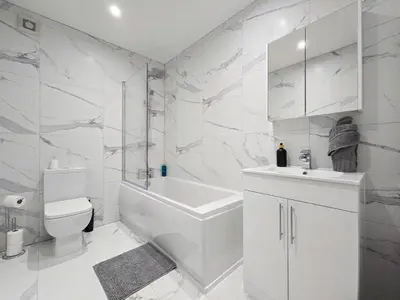 a white bathroom with a toilet and a sink at Luxury Seaside Apartments with Free Parking in Blackpool