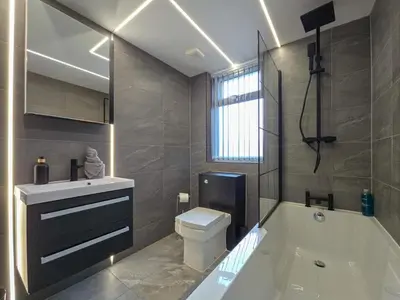 a bathroom with a tub and a toilet and a sink at Luxury Seaside Apartments with Free Parking in Blackpool