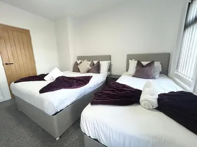 two beds in a hotel room with blankets on them at Luxury Seaside Apartments with Free Parking in Blackpool