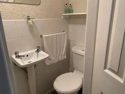 a small bathroom with a toilet and a sink at Sharn Bek Hotel in Blackpool