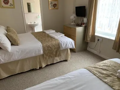 a hotel room with two beds and a sink at Sharn Bek Hotel in Blackpool