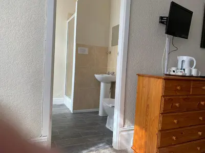 a bathroom with a sink and a toilet and a dresser at Sharn Bek Hotel in Blackpool