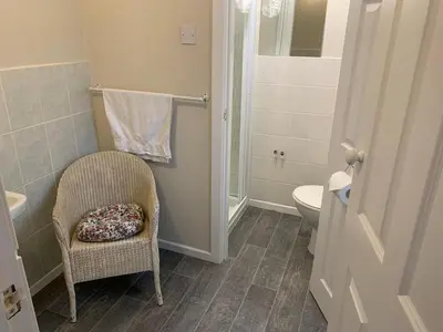 a bathroom with a chair and a toilet at Sharn Bek Hotel in Blackpool