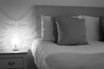 a white bed with a lamp on a night stand at Avalanche 1 Bed Apartment in Blackpool