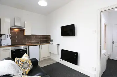 a living room with a couch and a kitchen at Avalanche 1 Bed Apartment in Blackpool